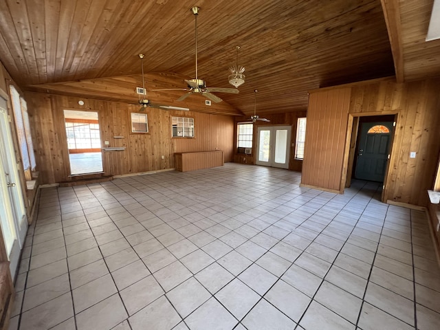 unfurnished living room with lofted ceiling, wooden ceiling, light tile patterned floors, and wood walls