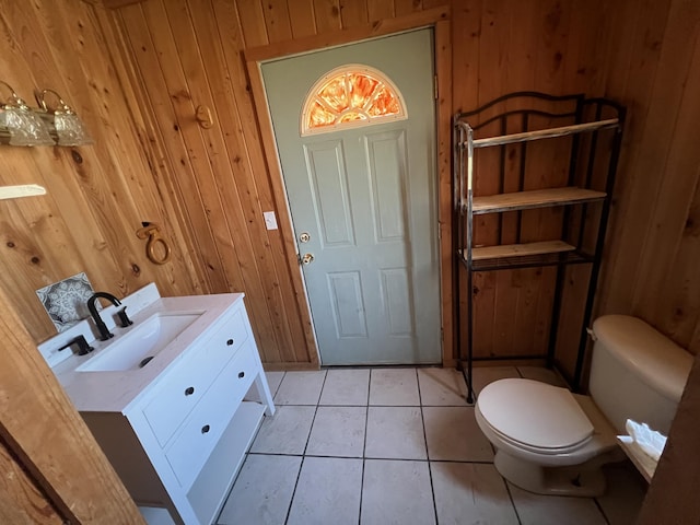 bathroom with wood walls, vanity, and tile patterned floors