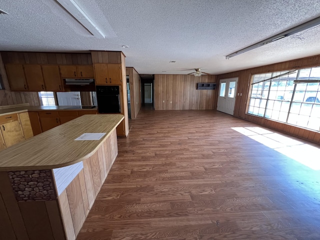 kitchen featuring a ceiling fan, dark wood-style floors, light countertops, a textured ceiling, and black appliances