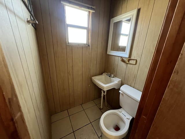 bathroom with wooden walls, toilet, and tile patterned floors