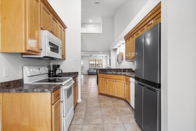 kitchen with light tile patterned flooring, recessed lighting, white appliances, a ceiling fan, and dark stone counters