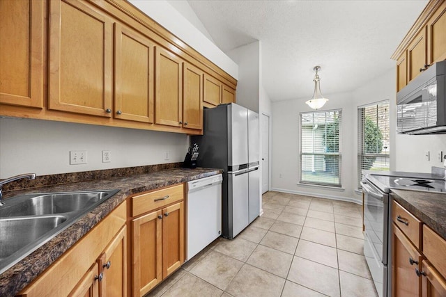 kitchen featuring light tile patterned flooring, white appliances, a sink, dark countertops, and pendant lighting