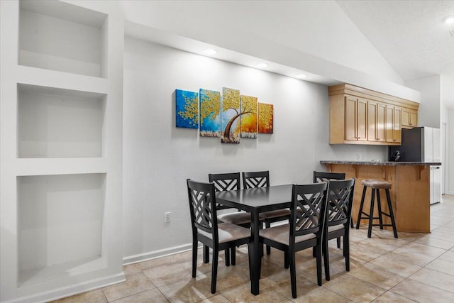 dining space with recessed lighting, light tile patterned flooring, vaulted ceiling, and baseboards