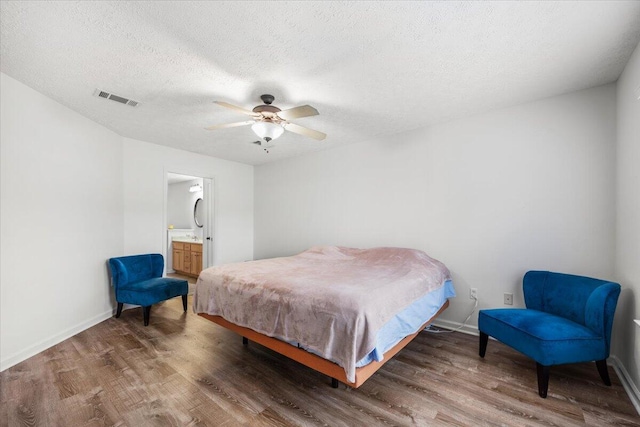 bedroom with dark wood-style floors, visible vents, and baseboards