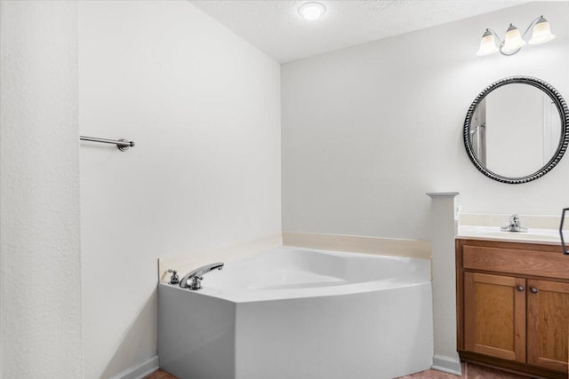 full bathroom with vanity, a textured ceiling, and a bath