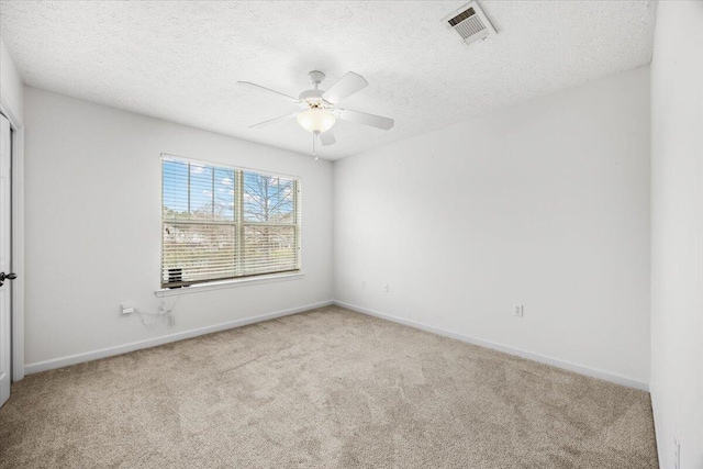 unfurnished room featuring baseboards, visible vents, a textured ceiling, and light colored carpet