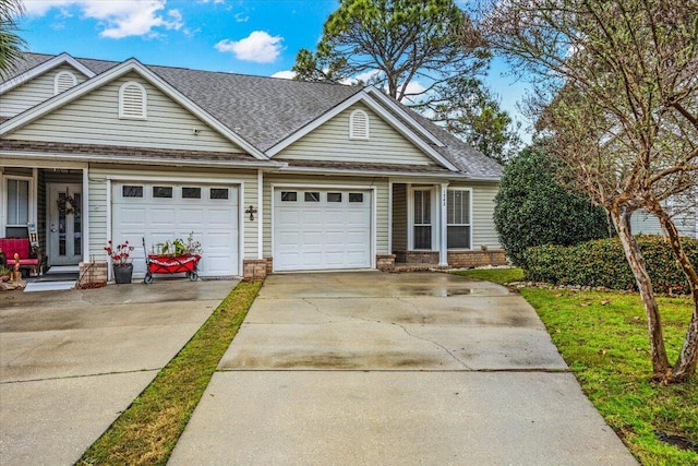 view of front facade featuring a garage, a shingled roof, concrete driveway, and brick siding