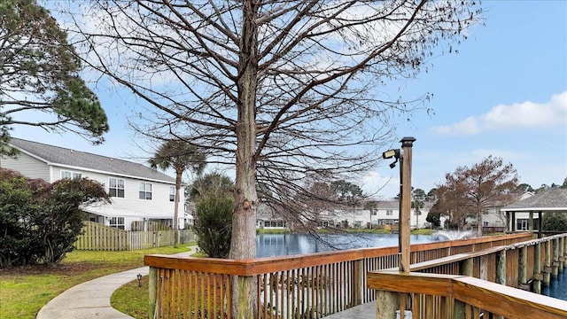 deck with a water view, fence, and a residential view