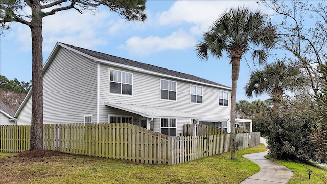 back of property with a fenced front yard and a lawn