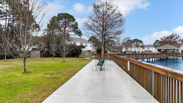 exterior space featuring a residential view, a water view, and a lawn