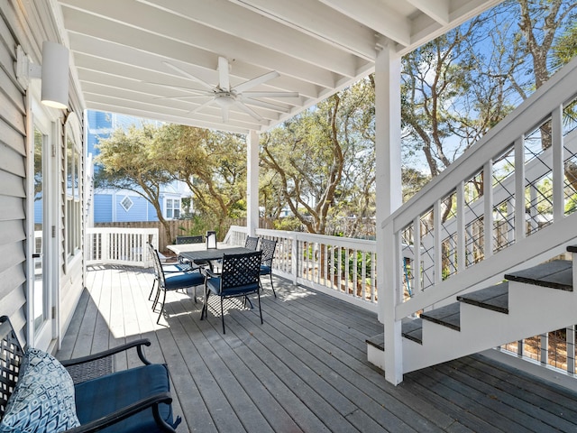 wooden terrace with outdoor dining area and ceiling fan