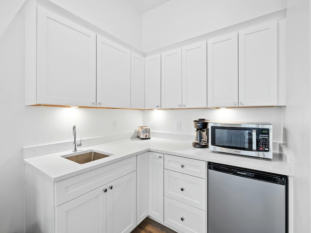 kitchen with dishwashing machine, refrigerator, a sink, white cabinetry, and stainless steel microwave