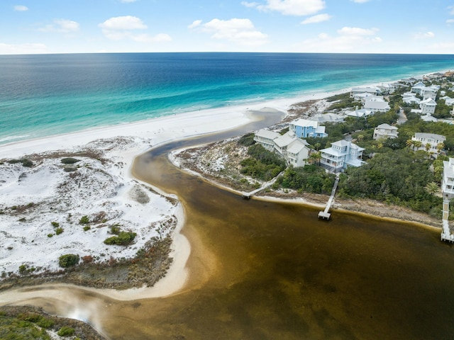 birds eye view of property with a water view and a beach view