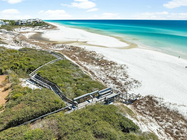 birds eye view of property with a water view and a beach view