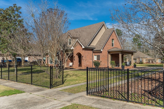 view of front of home featuring a fenced front yard, a front yard, a gate, and brick siding