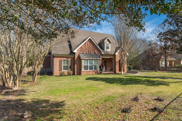 view of front of property featuring a shingled roof, a front yard, brick siding, and fence