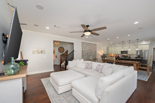 living area with stairs, dark wood finished floors, crown molding, and recessed lighting