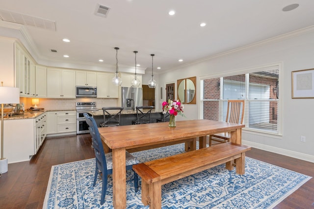 dining space with baseboards, dark wood-type flooring, visible vents, and crown molding