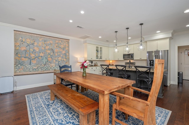 dining space with baseboards, dark wood-style flooring, visible vents, and crown molding