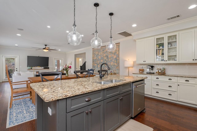 kitchen with crown molding, gray cabinets, white cabinets, a sink, and an island with sink