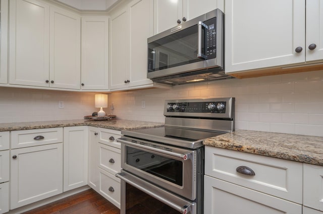 kitchen featuring stainless steel appliances, white cabinetry, and light stone counters