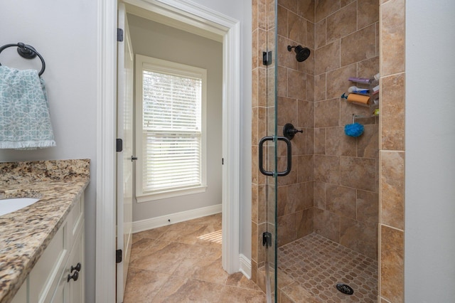 bathroom featuring a stall shower, vanity, and baseboards