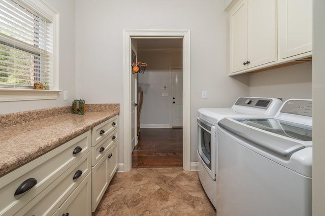 clothes washing area featuring cabinet space, baseboards, and independent washer and dryer