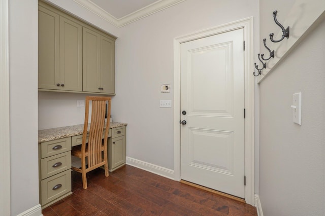 office area with dark wood-type flooring, built in study area, crown molding, and baseboards