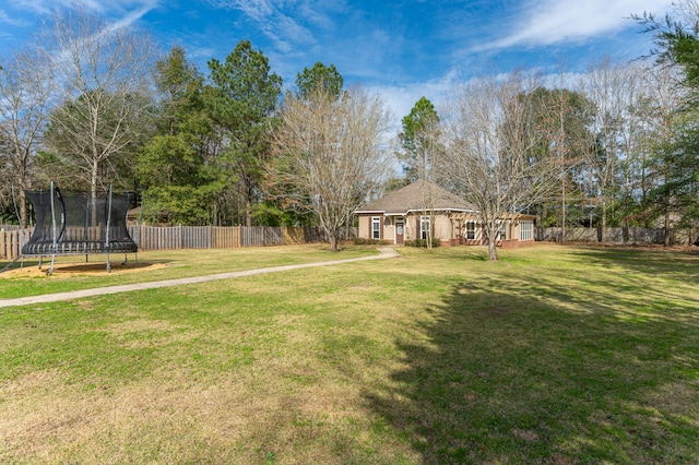 view of yard with a fenced backyard and a trampoline