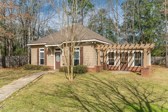 view of front facade featuring fence, a front lawn, and brick siding