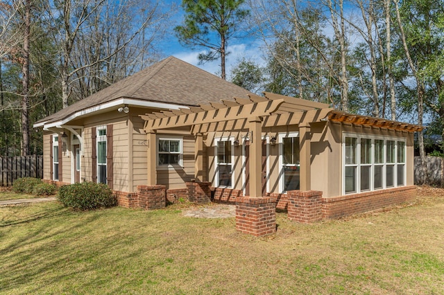 rear view of house with a shingled roof, brick siding, a yard, and a pergola