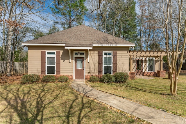 view of front of home featuring brick siding, a shingled roof, fence, a pergola, and a front yard