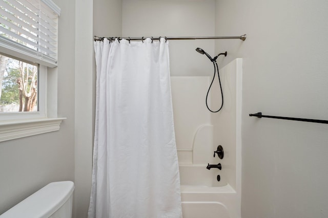 bathroom featuring toilet and shower / bath combo with shower curtain