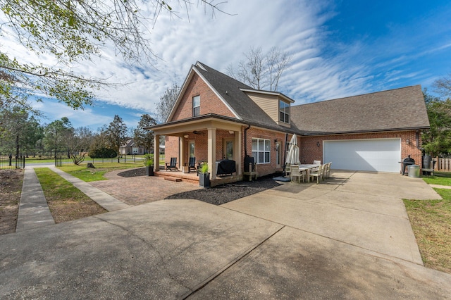 view of front of property featuring concrete driveway, brick siding, an attached garage, and covered porch