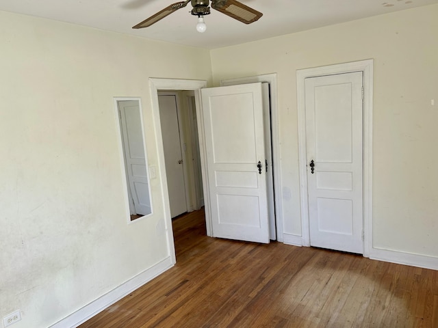 unfurnished bedroom featuring ceiling fan, dark wood finished floors, and baseboards