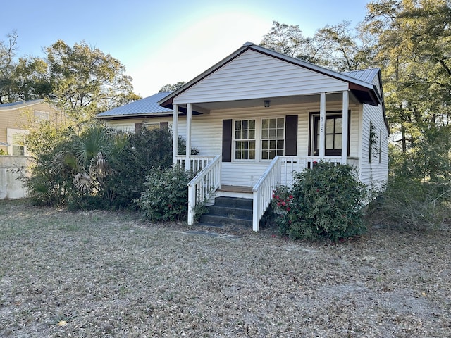 bungalow-style home with metal roof and a porch