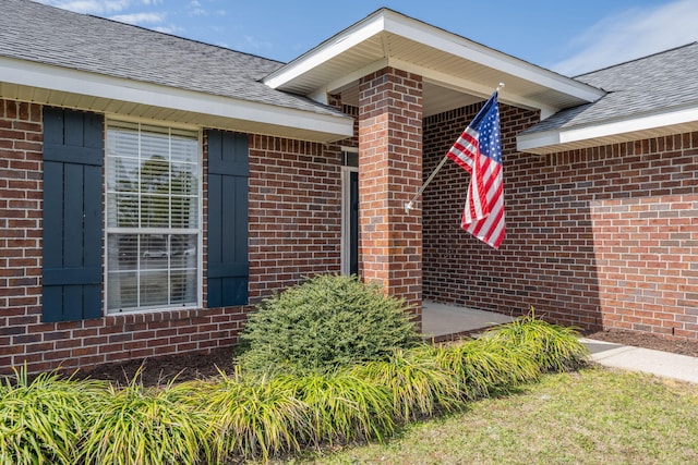 property entrance with brick siding and roof with shingles