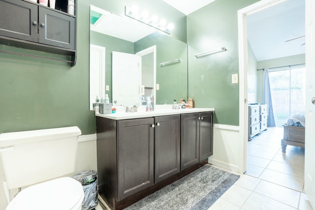 bathroom featuring toilet, tile patterned flooring, baseboards, and vanity