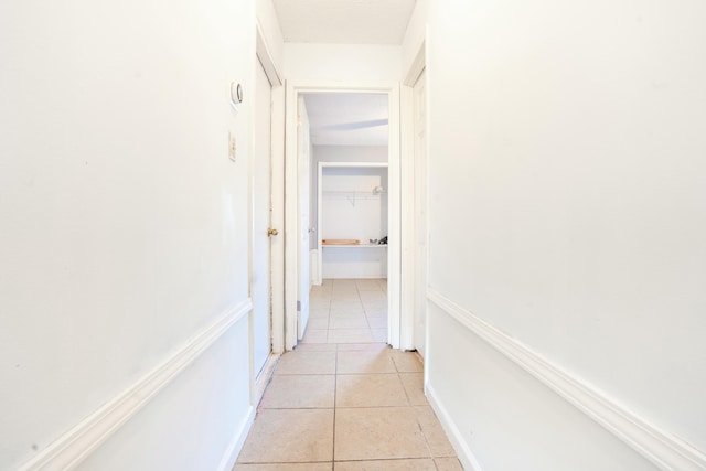 corridor with a textured ceiling and light tile patterned floors