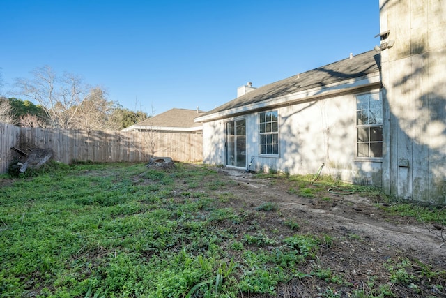 back of house featuring a chimney and fence