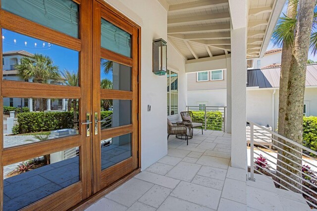 entryway featuring stone tile flooring, beam ceiling, french doors, and wood ceiling