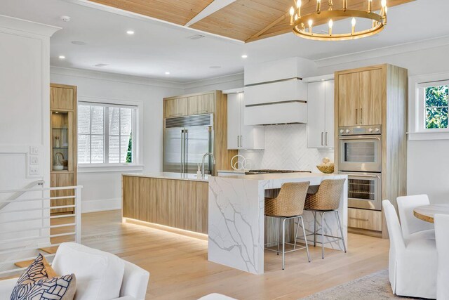 kitchen with stainless steel appliances, light brown cabinetry, backsplash, wood ceiling, and light wood-style floors