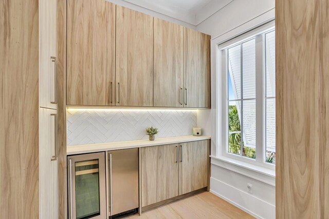 bar featuring wine cooler, stainless steel fridge, backsplash, and light wood-style floors