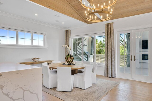 dining area featuring wood ceiling, light wood-type flooring, high vaulted ceiling, a chandelier, and french doors