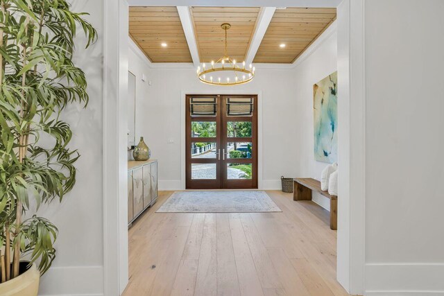 doorway to outside featuring wooden ceiling, a chandelier, beam ceiling, light wood-style flooring, and french doors