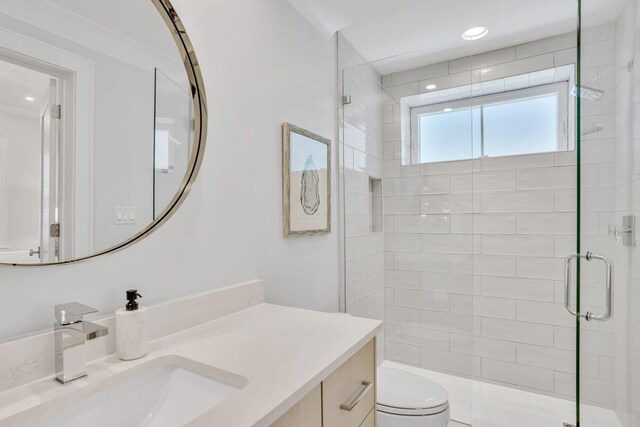 bathroom with toilet, a stall shower, vanity, and recessed lighting
