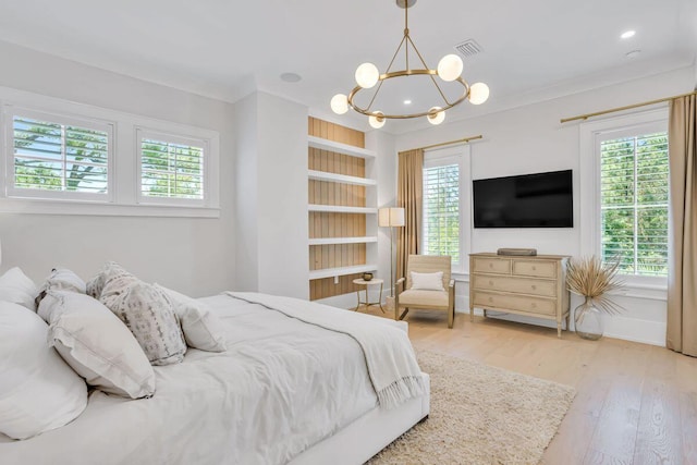 bedroom featuring a chandelier, wood-type flooring, ornamental molding, and baseboards