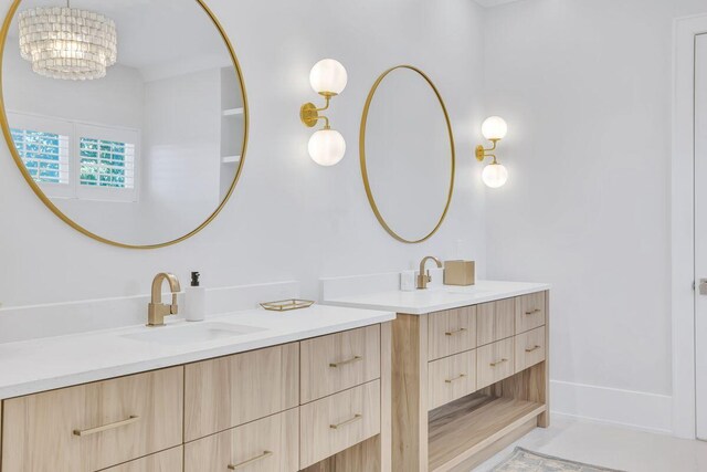 bathroom featuring two vanities and a chandelier