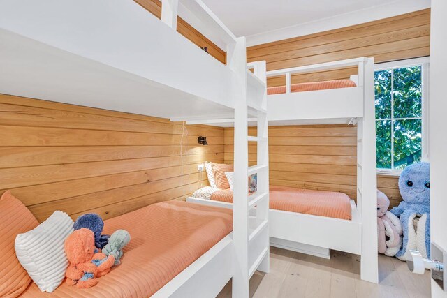 bedroom featuring wood finished floors and wooden walls