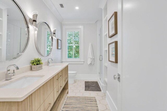 bathroom featuring toilet, a stall shower, double vanity, baseboards, and tile patterned floors